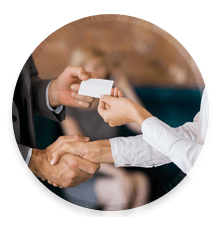 man and woman shaking hands and exchanging a business card