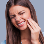 stock photo of a woman in pain holding jaw