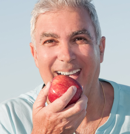 man smiling eating apple