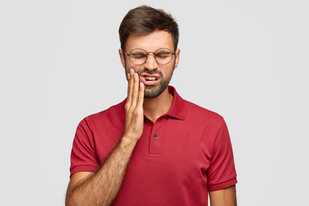 A man holding his mouth in pain