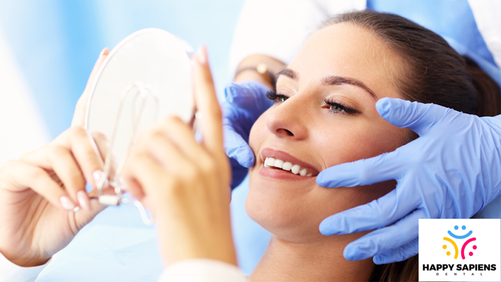 A dental patient admiring her teeth in a mirror.